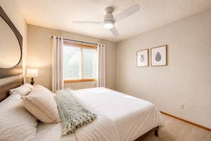A bedroom with a bed, a ceiling fan, a window with curtains, and two framed pictures on the wall. - Family-Friendly | Firepit | Kayaks | Fishing Lakes (Black Hawk)