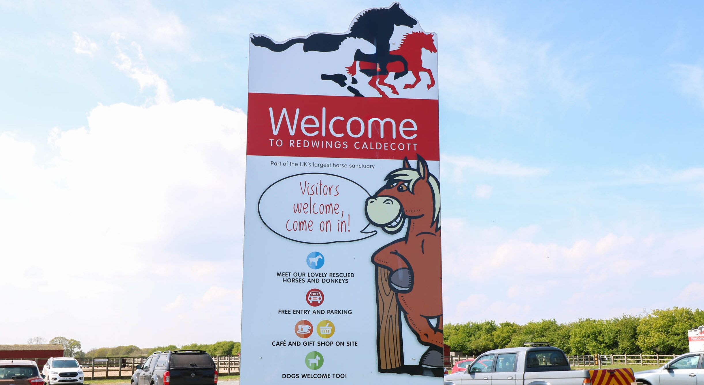 Une pancarte d’accueil indiquant le nom du refuge pour chevaux Redwings Caldecott, avec des informations sur les heures d’ouverture et les équipements disponibles.