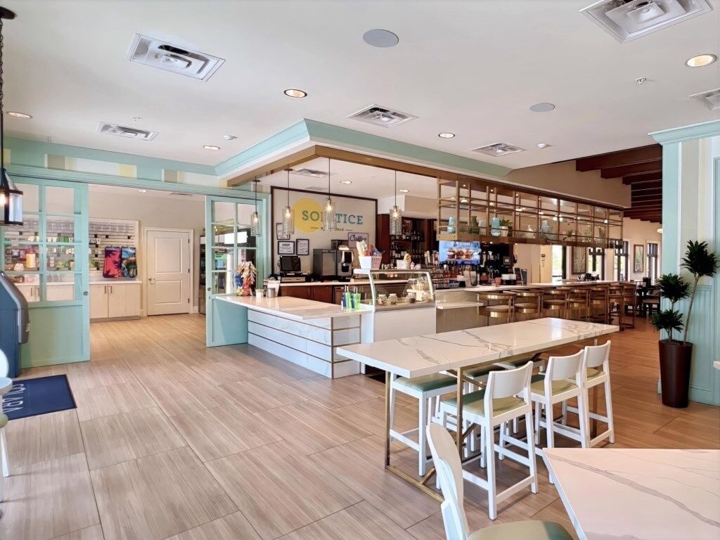 A spacious kitchen with a central island, a bar area, and a seating area with chairs.