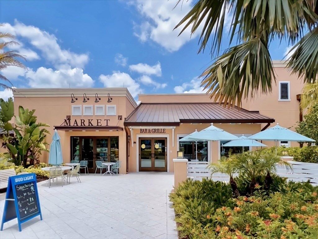 A market with a bar and grill, outdoor seating, and a Bud Light sign.