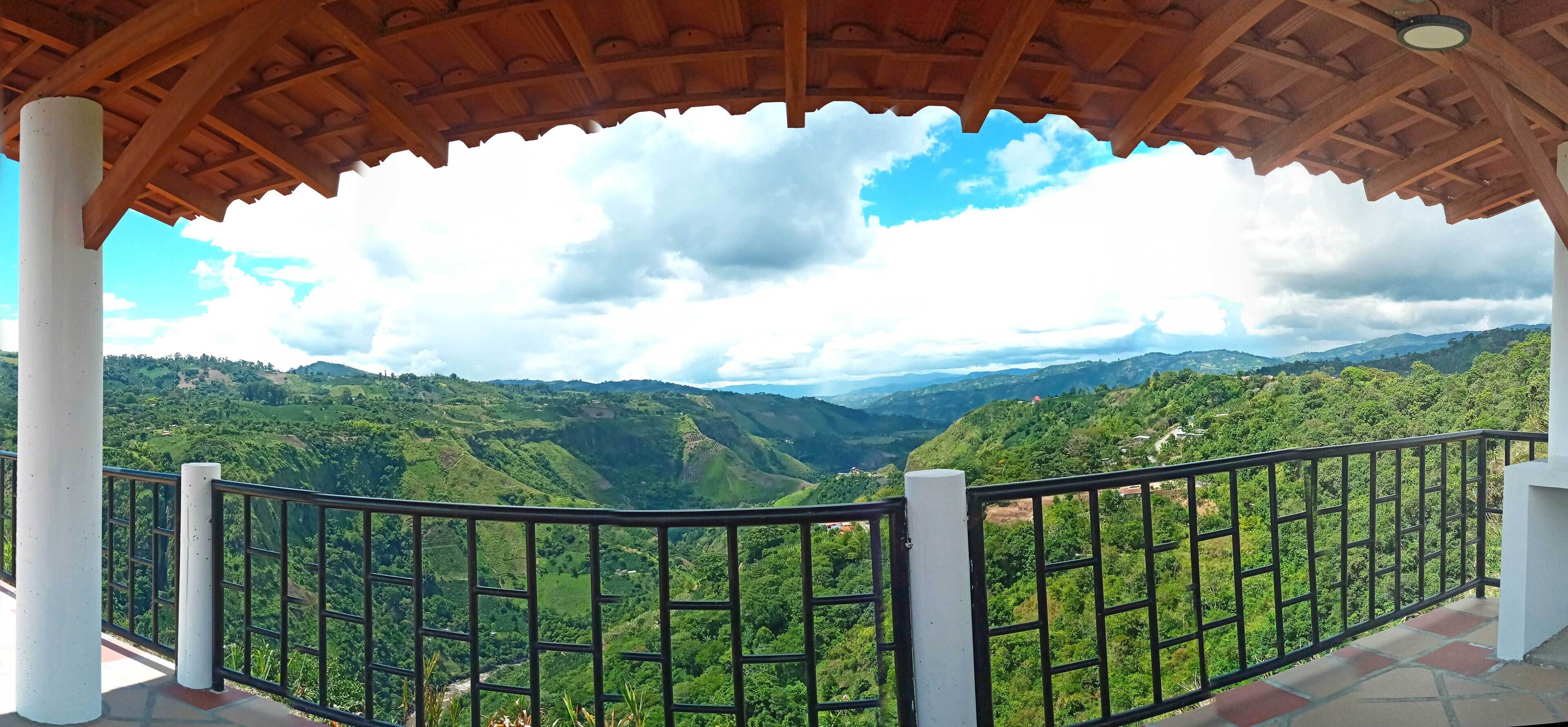 Una pèrgola de fusta amb vista a una vall i muntanyes.