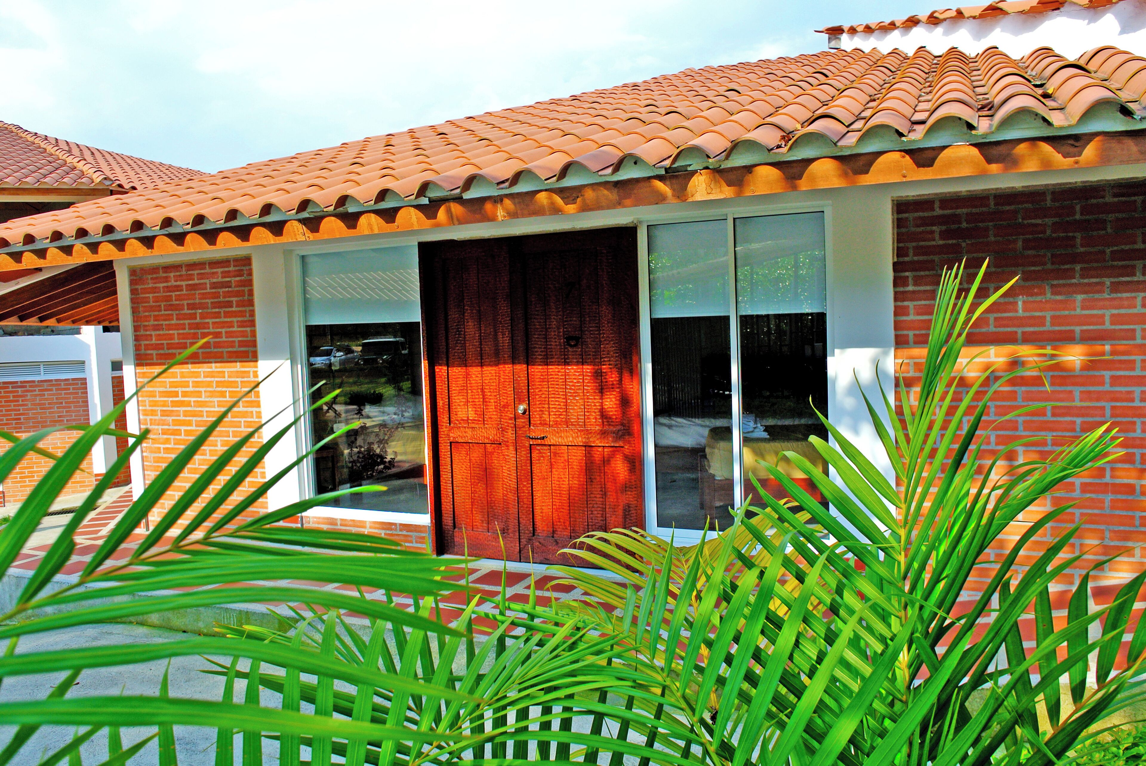 Una casa con techo de tejas, fachada de ladrillo y puerta de madera.