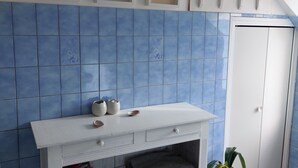 A bathroom with a white vanity, blue tiles, framed pictures, and a white door. - Charmante Maison de Village , Tout à Pied, Commerces et Plage à 5 mn (Perros-Guirec)