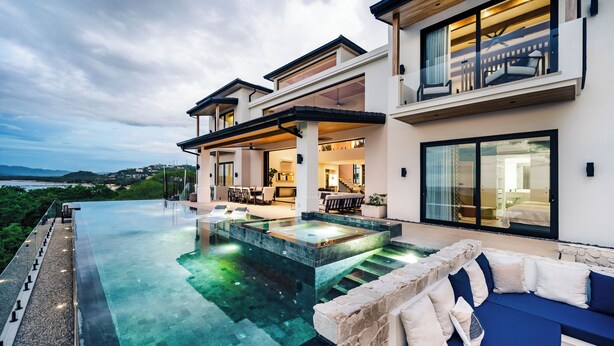 A modern house with an infinity pool, outdoor seating, and a view of the landscape. - Staffed Luxury Oceanview Villa w/ golfcart, jacuzzi, infinity pool &breakfast (Playa Tamarindo)