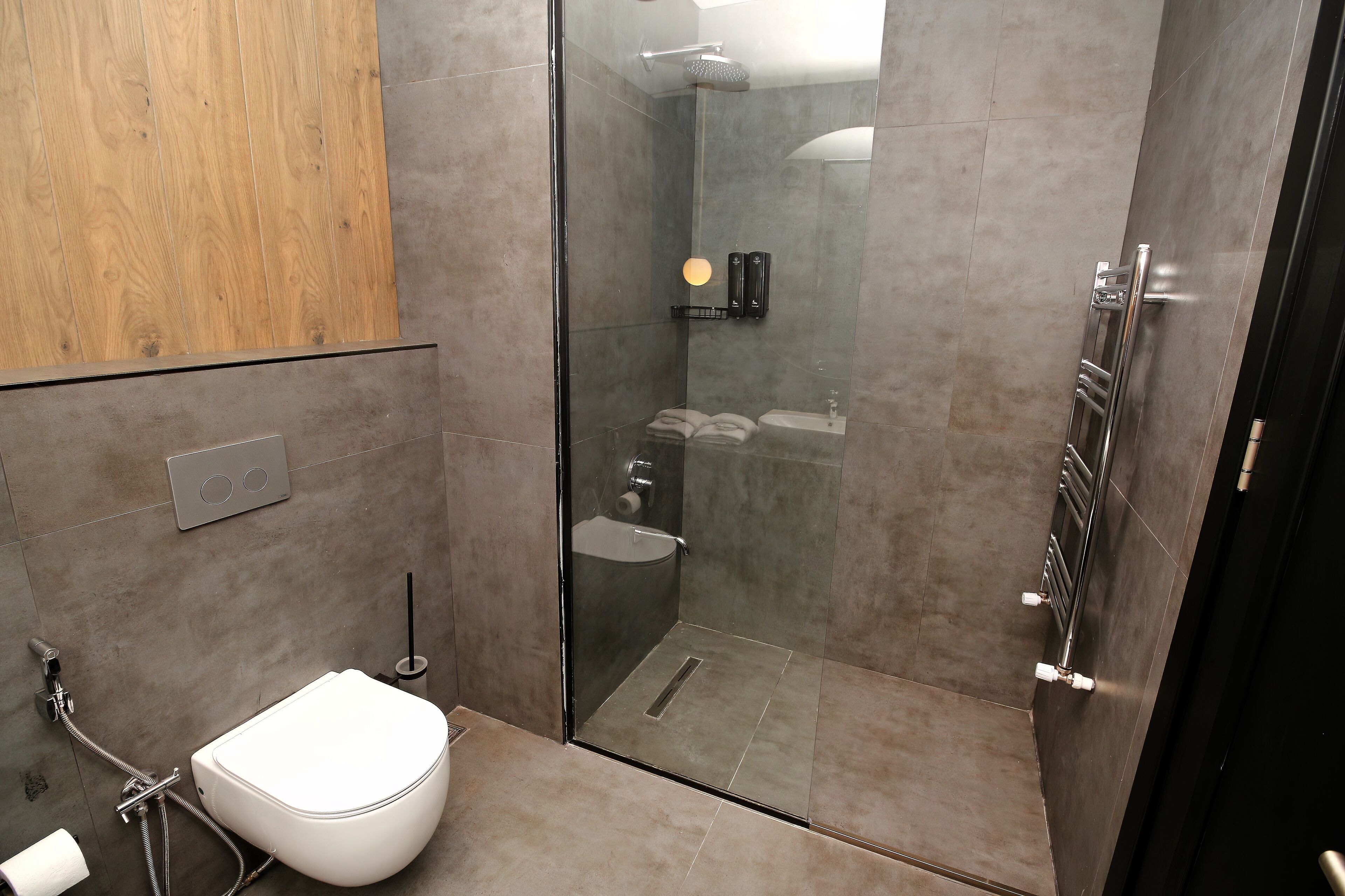 A modern bathroom with a glass-enclosed shower, a toilet, and a sink.