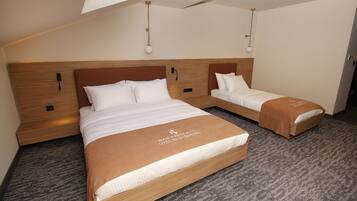 A hotel room with two beds, a wooden headboard, and a carpeted floor.