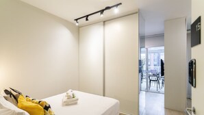 A bedroom with a bed, a sliding door, and a view of an outdoor area with chairs and a table. - Wish Moema 15 (São Paulo)
