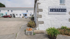 Un edificio bianco con un'insegna per la Cornish Art Gallery e Andrew Giddens.