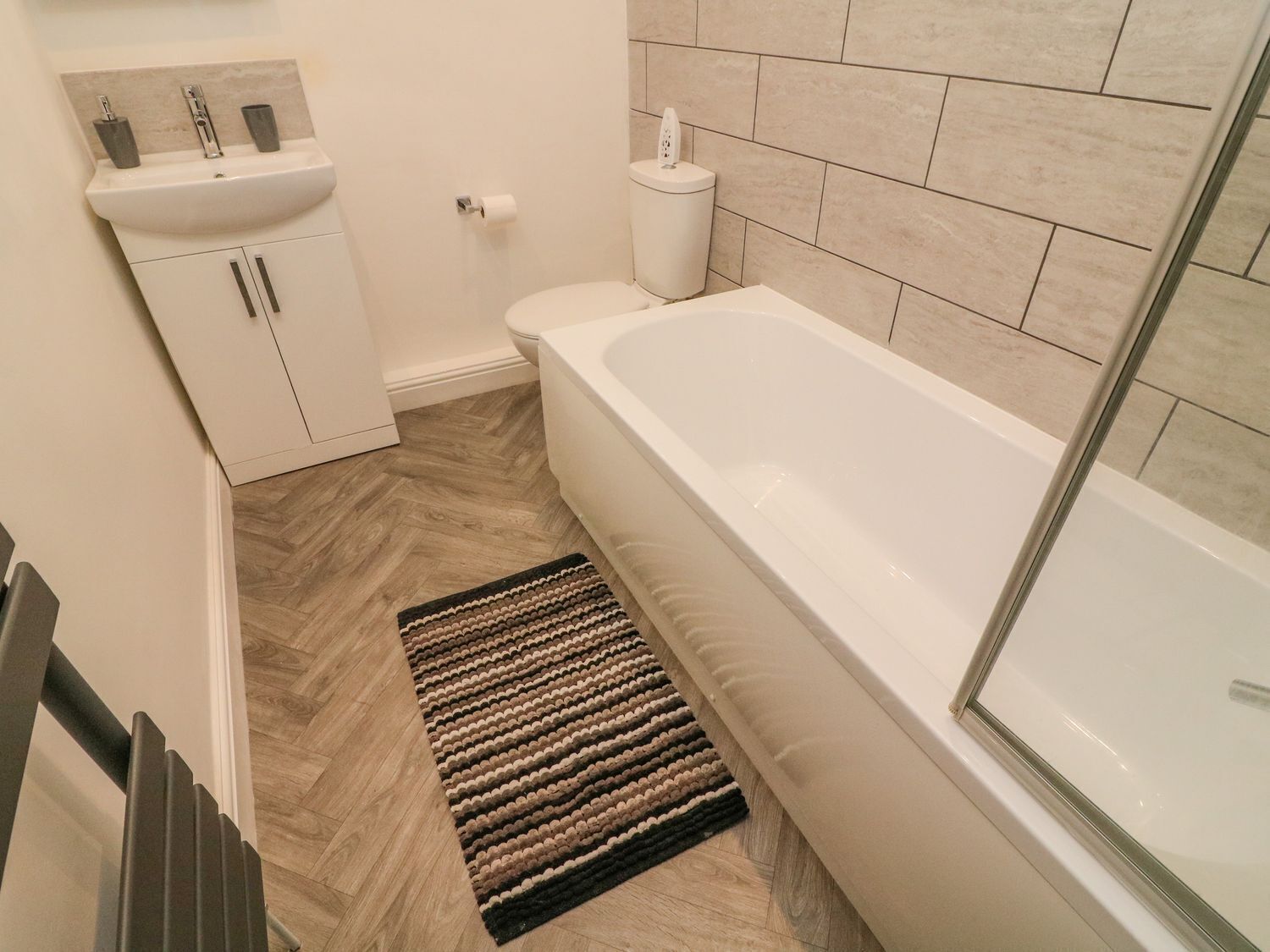 A bathroom with a white sink, toilet, and bathtub.