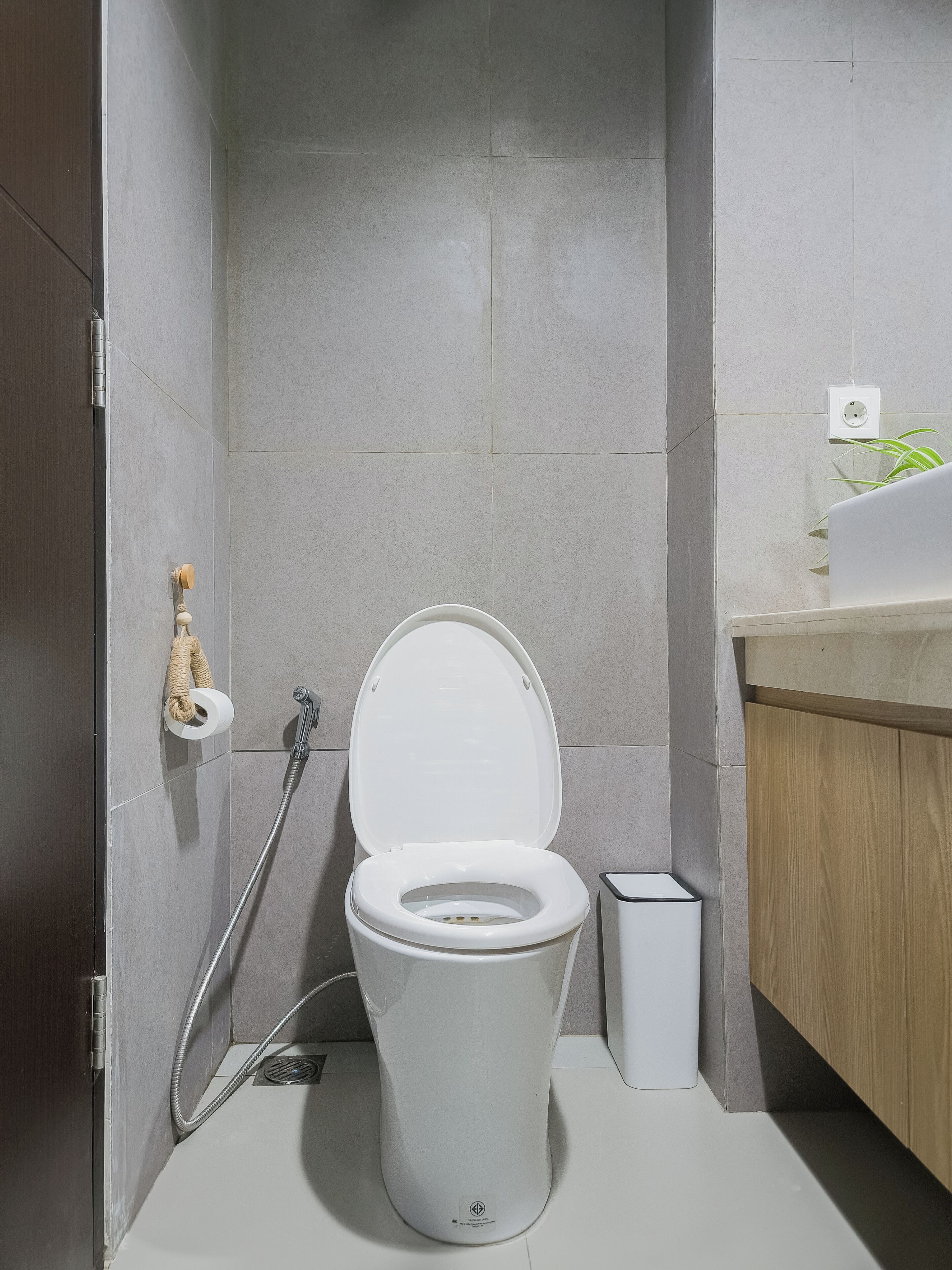 A modern bathroom with a white toilet, a shower, and a sink.
