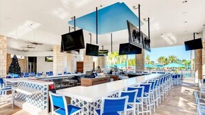 Zona de bar amb diverses opcions de seients, una llar de foc i un arbre de Nadal.