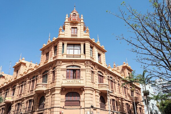 A historic building with ornate architecture, multiple balconies, and large windows.