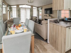 Un espacio habitable compacto con comedor, kitchenette y zona de estar.