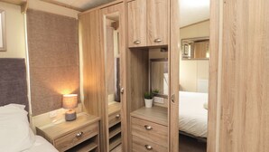 Une chambre à coucher avec une armoire en bois, une table de chevet avec une lampe et un lit.