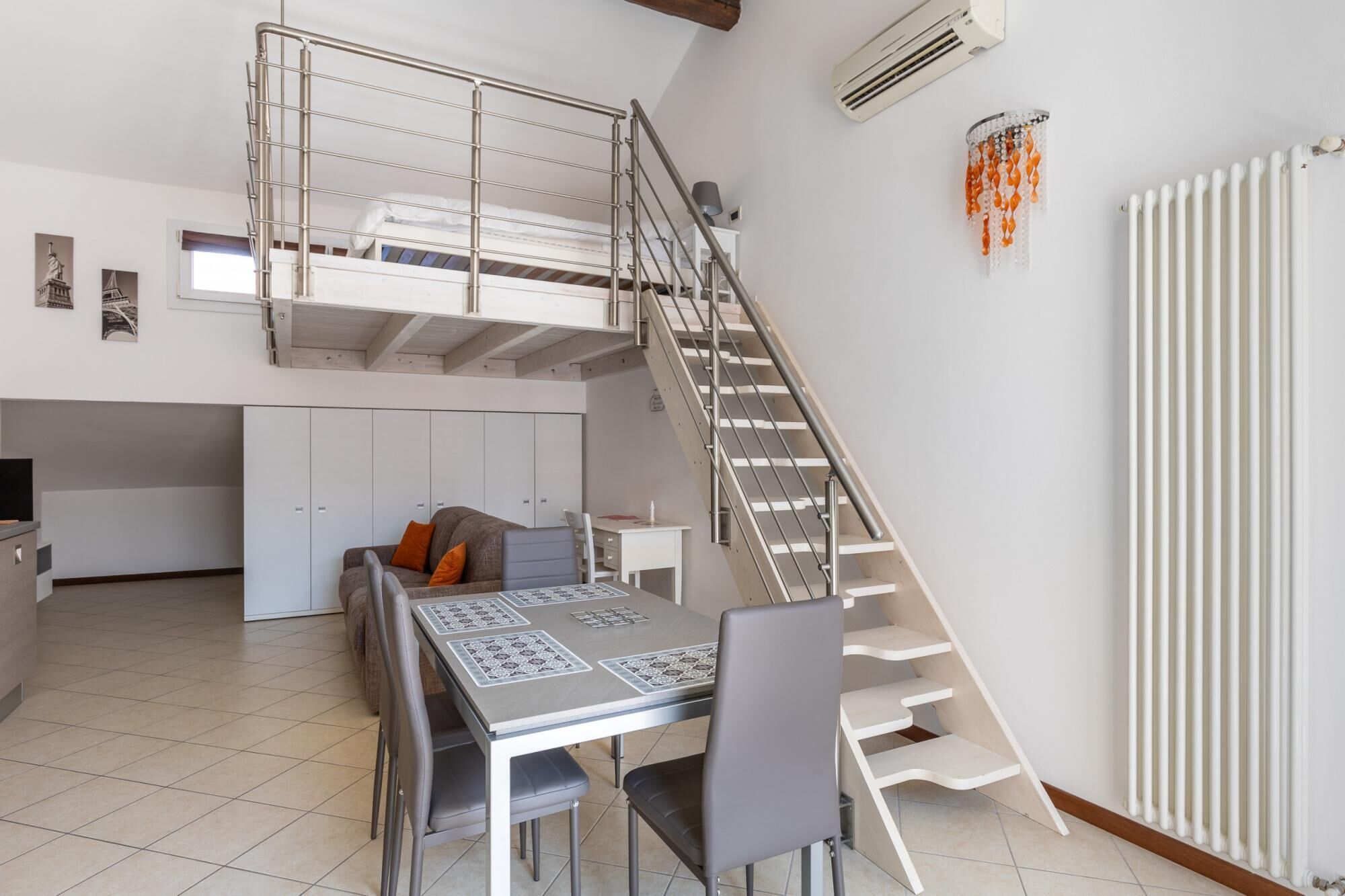 A compact living space with a loft bedroom, a dining area, and a kitchen.