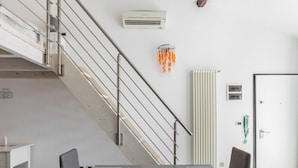 Une chambre d’hôtel moderne équipée d’un escalier, d’un radiateur, d’un climatiseur et d’une porte.
