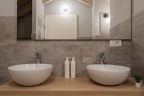 A bathroom with two large white sinks, a mirror above, and a small potted plant on the counter. - Le Casette del Balon by Wonderful Italy - 1-bedroom Apartment (Turin)