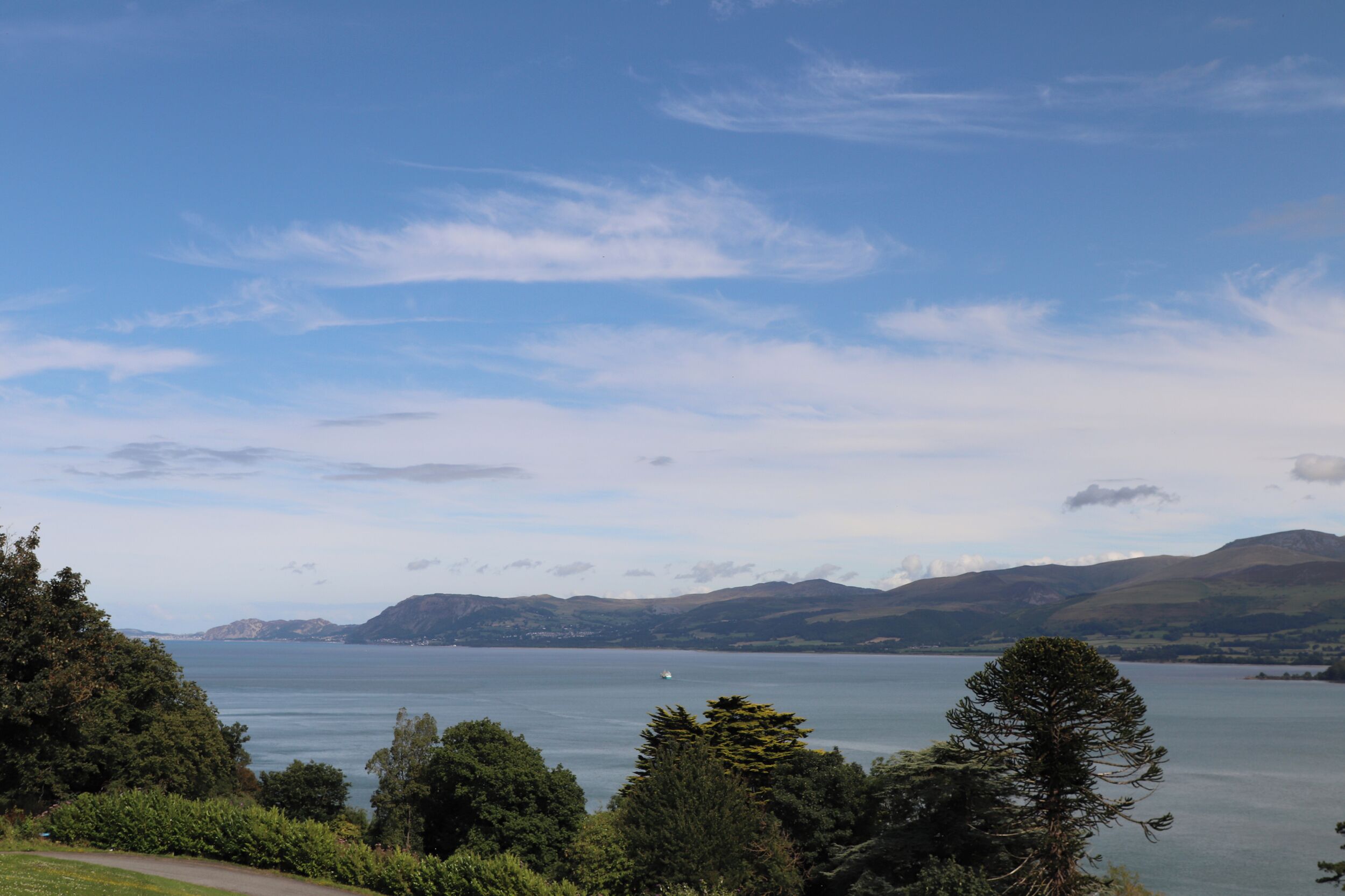 A scenic view of a lake with mountains in the background and a clear sky.