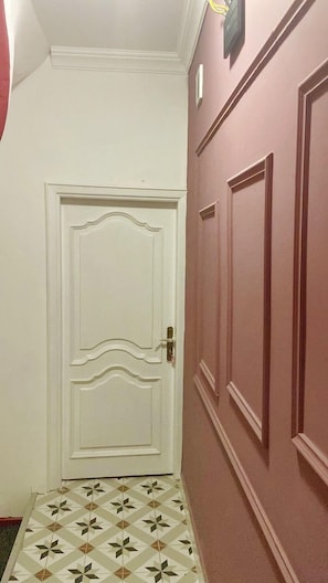 Stylish hallway with a decorative door and geometric-patterned floor.