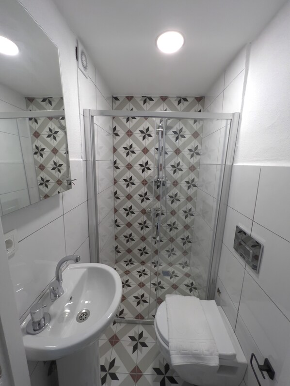 A bathroom with a sink, toilet, and shower.