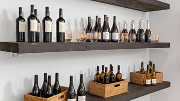Two shelves with wine bottles and glasses.