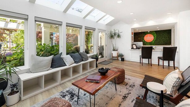 Un salon moderne doté d’une banquette intégrée, d’une table basse en bois et d’un coin repas avec des chaises.
