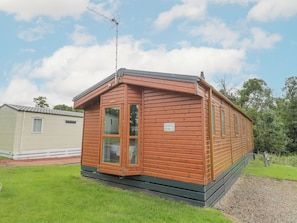 A wooden mobile home with a small porch, a window, and a sign that reads "Mulberry Lodge". - Mulberry Lodge (Morpeth)