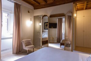 Een slaapkamer met een groot bed, een stoel, een kledingkast en een spiegel.