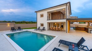 A modern two-story house with a swimming pool, outdoor seating, and a kitchen area. - Villa Dvor (Vodnjan)