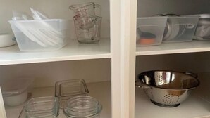 A kitchen shelf with storage containers, a measuring cup, and a colander. - Centrally located one bedroom + Office (Calgary)