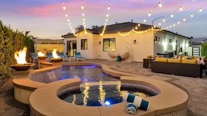 A pool area with a hot tub, lounge chairs, and string lights. - New+Modern/Pool/Spa/Gameroom/Poker/Massage chair (Indio)