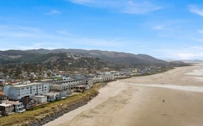 A coastal town with a sandy beach and a row of buildings along the shore.