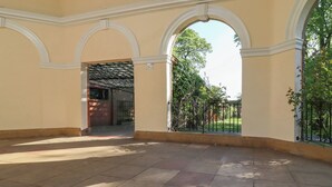 An empty courtyard with tiled flooring, arched doorways, and a view of a garden. - 3 Glendowne Terrace (Harrogate)