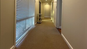 A narrow, carpeted hallway with white walls and a ceiling light. - Hill top view house, high speed wifi, Netflix & Prime Video (Sunbury)