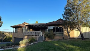 A two-story house with a covered porch, a brick exterior, and a well-maintained lawn. - Hill top view house, high speed wifi, Netflix & Prime Video (Sunbury)
