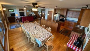 Una cocina amplia con armarios de madera, un comedor con mantel estampado y una estación para café.