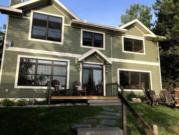 View of home from dock. 2 short sets of steps with railings down to dock