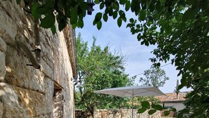 Eine Terrasse im Freien mit Steinmauern, einem Pool und Gartenmöbeln.