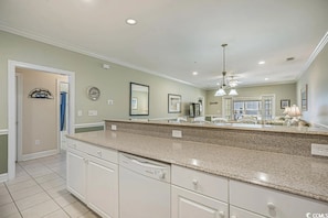 A kitchen with a large island, white cabinets, and a modern design.