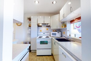 Enjoy cooking in this well-equipped kitchen with an oven, microwave, and stainless steel range hood.