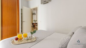 Une chambre d’hôtel avec un lit, un plateau contenant des articles pour le petit-déjeuner et un téléviseur fixé au mur.