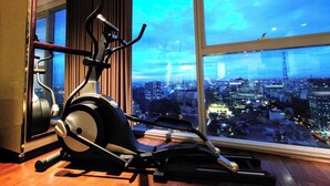 A gym with an exercise bike and a treadmill, large windows with a city view. - The Rixx Vincom Center (Ho Chi Minh City)