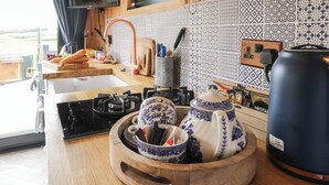 Una cocina con mostrador de madera, un fregadero, una estufa y salpicadero de azulejos.