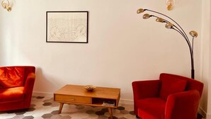 A room with a red sofa, a wooden coffee table, and a floor lamp. - chiesa russa (Bari)