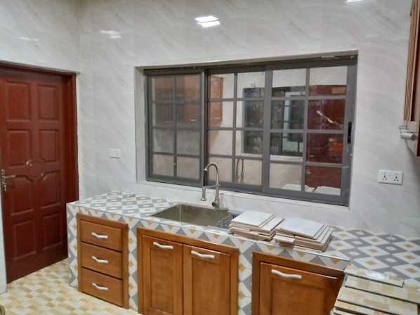 A kitchen with a window, wooden cabinets, and a tiled backsplash.