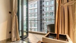 A modern hotel room with a large window, a sliding door, and a small indoor fountain. - The Rixx D1 Mension (Ho Chi Minh City)