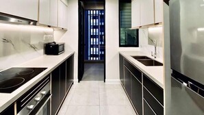 A modern kitchen with a central island, built-in oven, and stainless steel appliances. - The Rixx D1 Mension (Ho Chi Minh City)