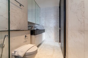 A modern bathroom with a toilet, sink, and glass shower enclosure. - The Rixx D1 Mension (Ho Chi Minh City)