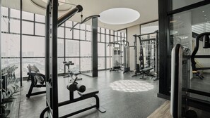 A modern gym with large windows, various exercise equipment, and a view of the cityscape. - The Rixx D1 Mension (Ho Chi Minh City)