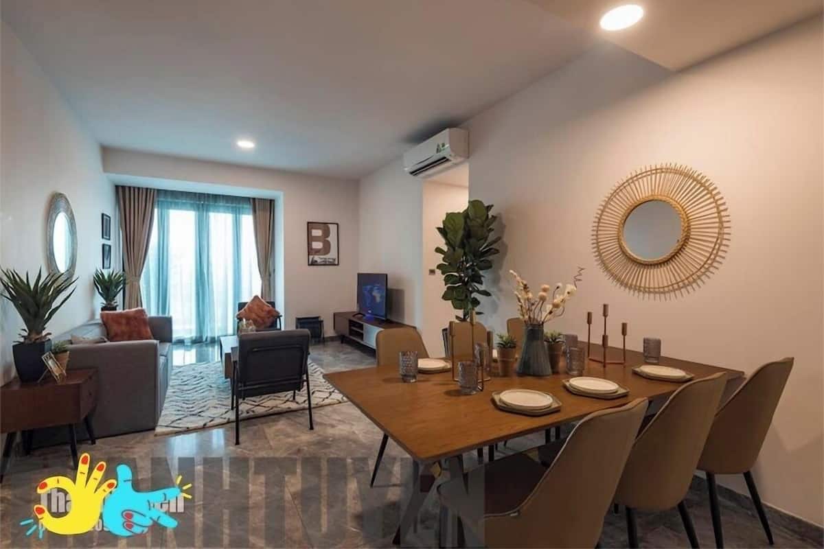 A modern living room with a dining area, featuring a sofa, a coffee table, and a TV.